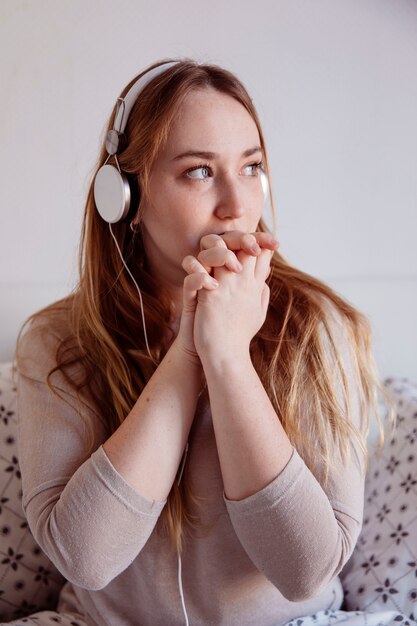 Linda mujer en auriculares mirando hacia otro lado