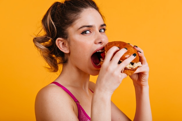 Foto gratuita linda mujer blanca come hamburguesa