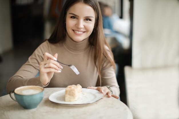 linda mujer en un café comiendo y sonriendo