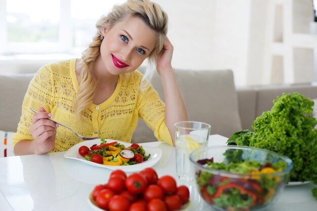 linda mujer en casa con ensalada