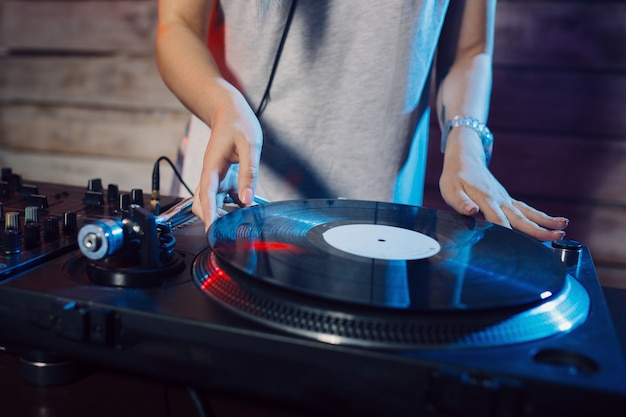 Linda mujer dj divirtiéndose tocando música en la fiesta del club