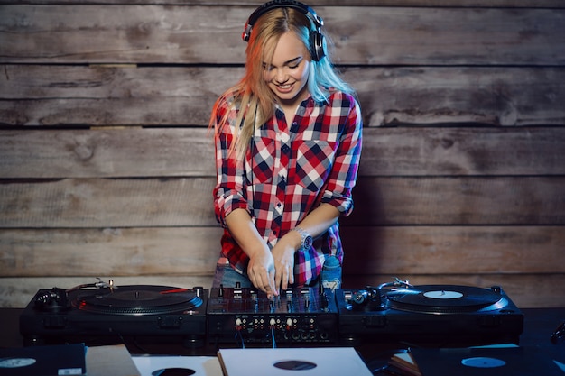 Linda mujer dj divirtiéndose tocando música en la fiesta del club