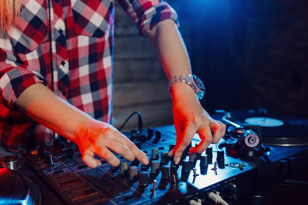 Linda mujer dj divirtiéndose tocando música en la fiesta del club