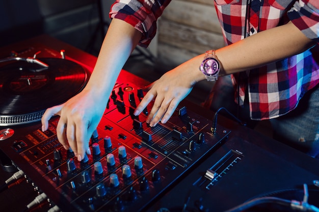 Linda mujer dj divirtiéndose tocando música en la fiesta del club