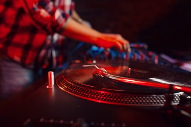 Linda mujer dj divirtiéndose tocando música en la fiesta del club