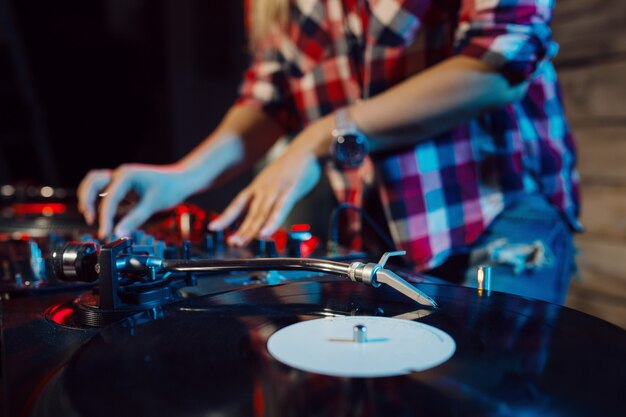 Linda mujer dj divirtiéndose tocando música en la fiesta del club