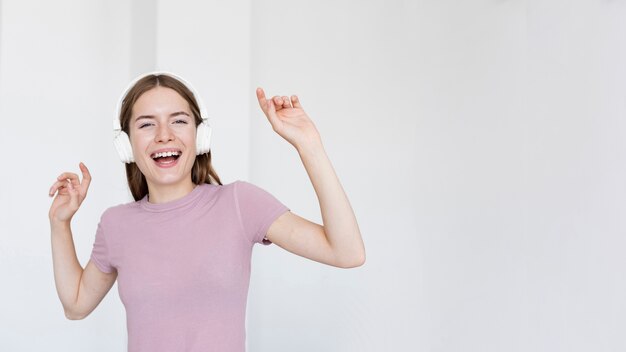 Foto gratuita linda mujer escuchando música con espacio de copia