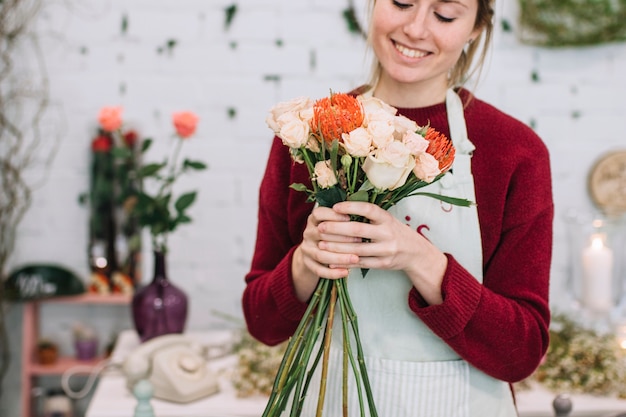 Foto gratuita linda mujer con flores en la tienda