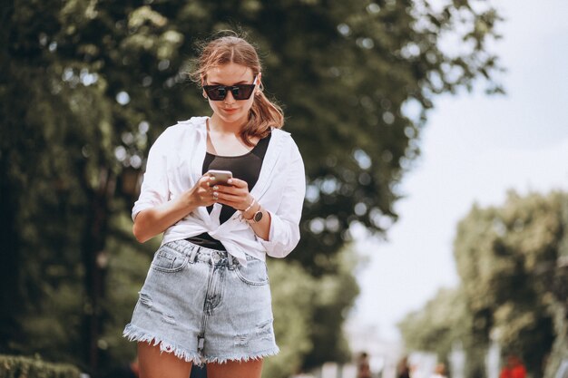 Linda mujer fuera de la calle con teléfono