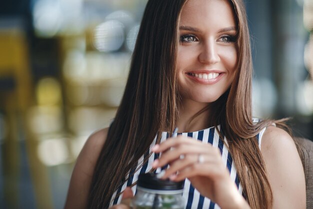 linda mujer joven con café en el café de la terraza