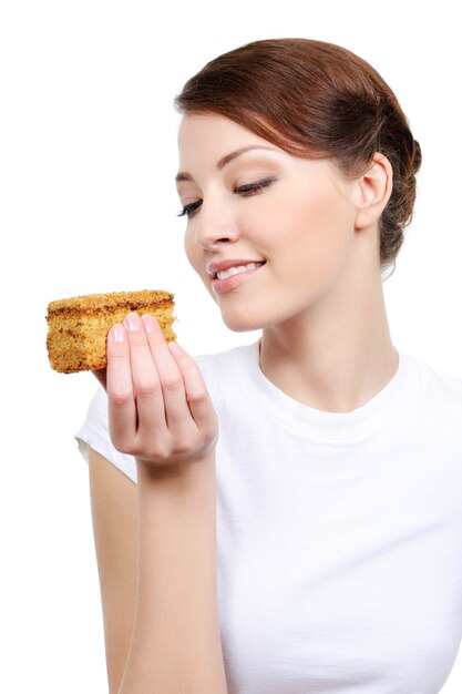 Linda mujer joven comiendo pastel - aislado en blanco