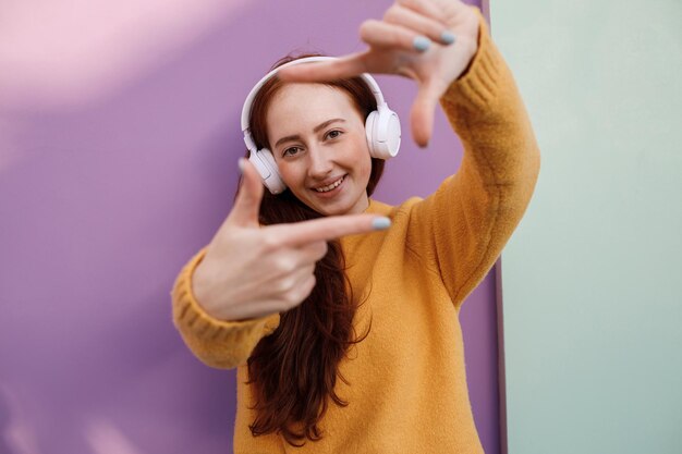 linda mujer joven escucha la música en los auriculares al aire libre