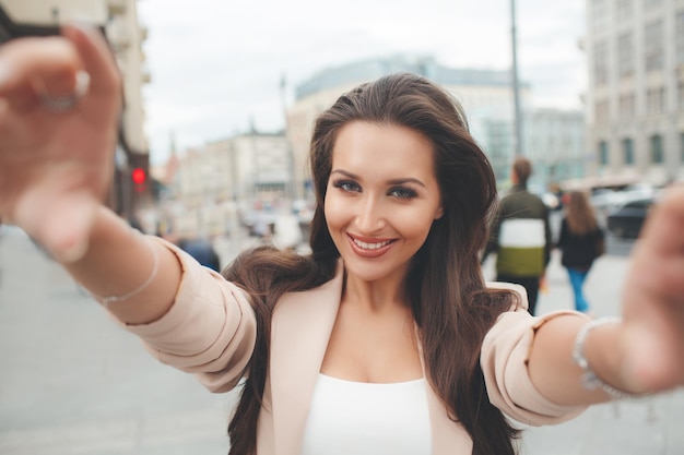 linda mujer joven con las manos en la cámara al aire libre