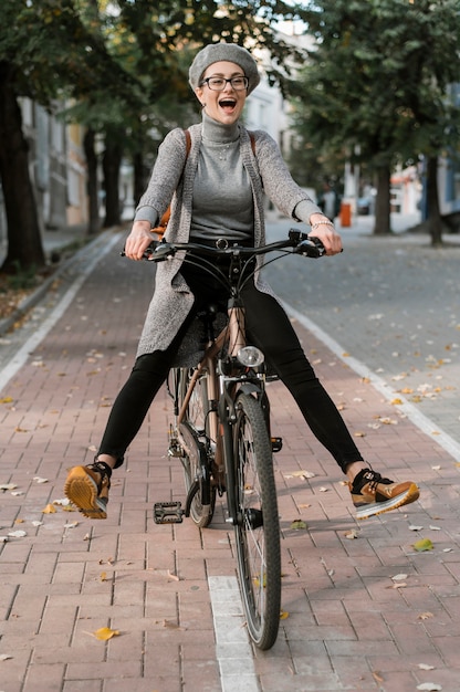 Foto gratuita linda mujer jugando con su bicicleta