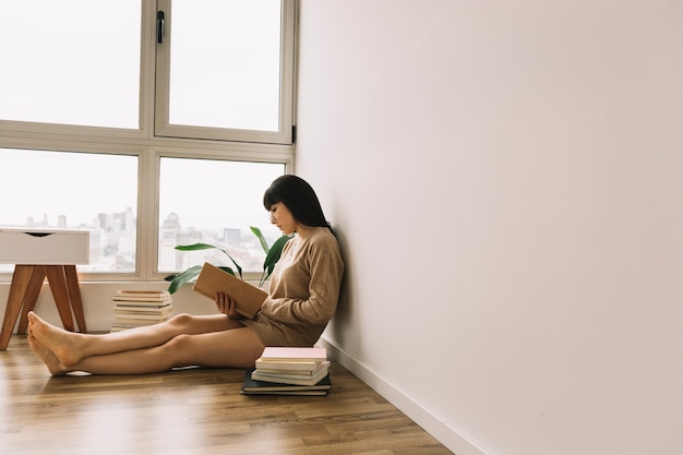 Linda mujer leyendo en el piso