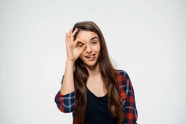 Foto gratuita linda mujer muestra signo bien y lengua de palo