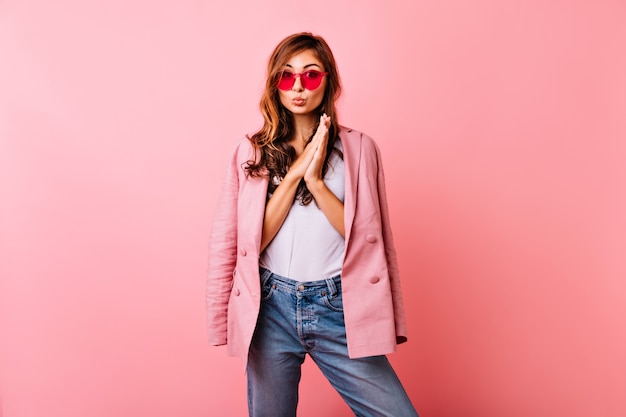 Linda mujer pelirroja en traje de moda posando con expresión de la cara interesada. Modelo de mujer de jengibre sensual pasar tiempo.