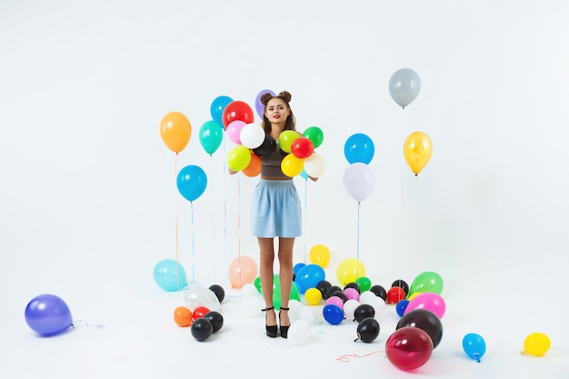 Linda mujer posando con coloridos globos de helio después de la gran fiesta