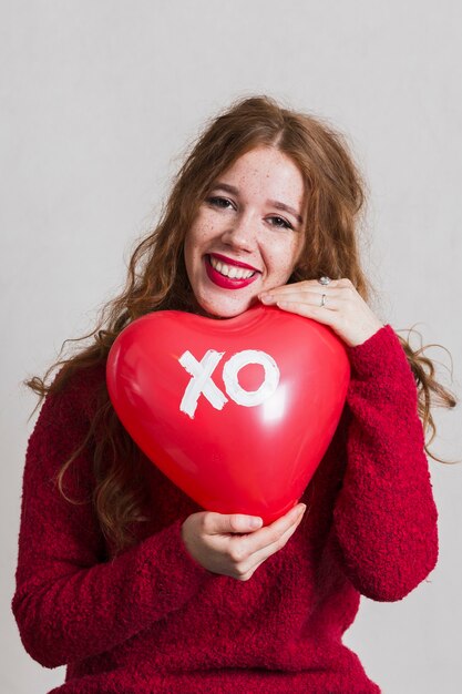 Linda mujer posando con un globo de corazón