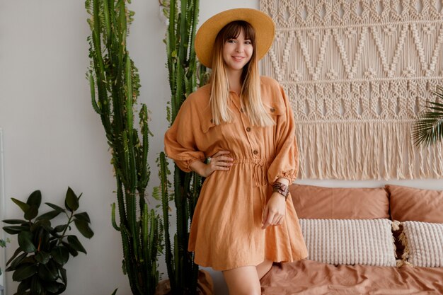 Linda mujer posando en vestido de lino en su habitación