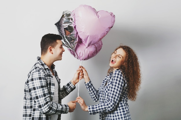 Linda mujer rizada alegre feliz de recibir globos de corazón de novio que es muy romántico