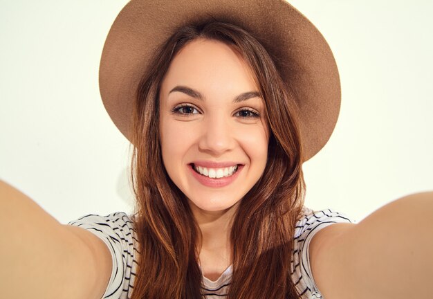 Linda mujer en ropa hipster de verano tomar selfie de manos con teléfono