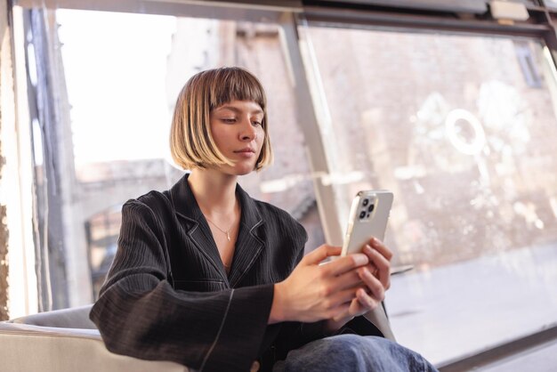 Linda mujer sentada en un café con teléfono