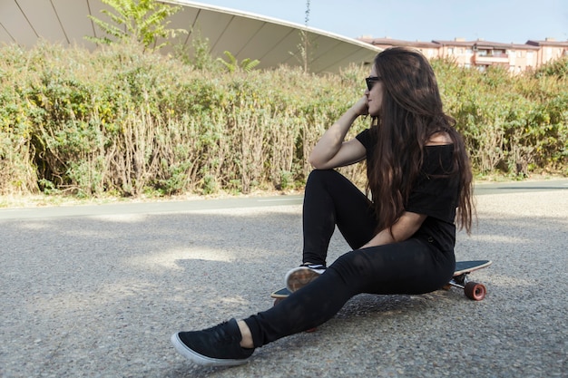 Linda mujer sentada en longboard