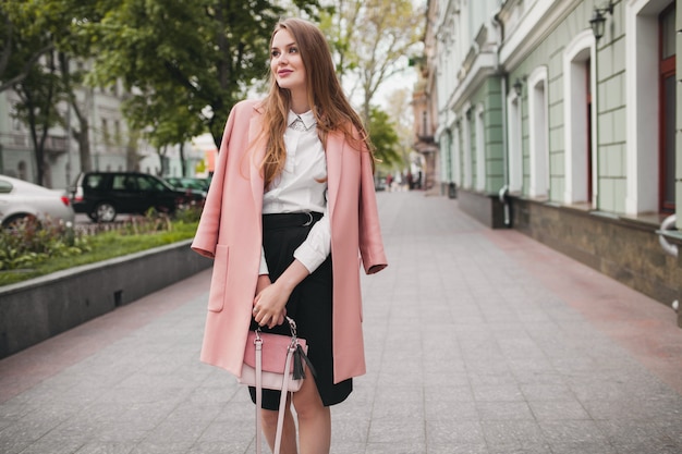 Linda mujer sonriente elegante atractiva caminando calle de la ciudad en abrigo rosa