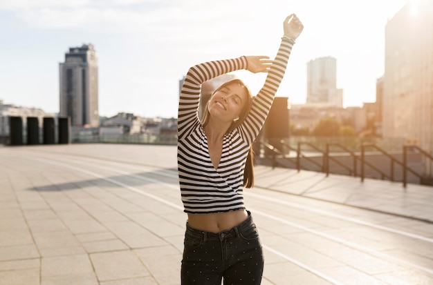 Linda mujer sonriente posando en la luz del sol