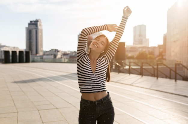 Linda mujer sonriente posando en la luz del sol