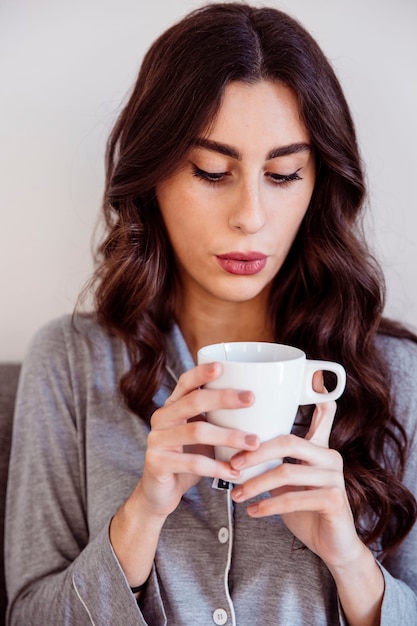 Foto gratuita linda mujer soplando en el té