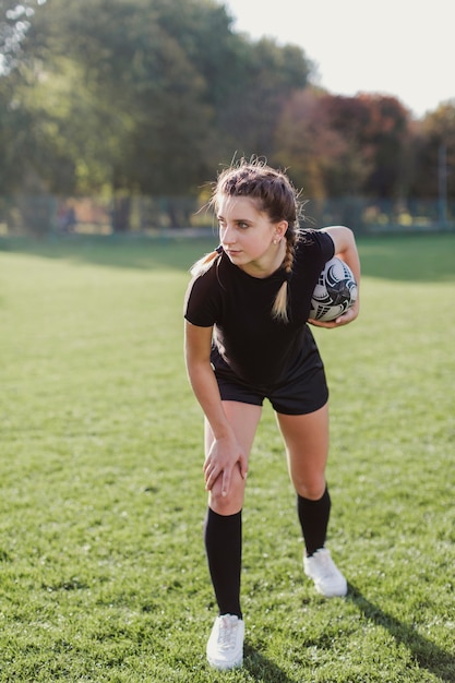 Foto gratuita linda mujer sosteniendo una pelota de rugby