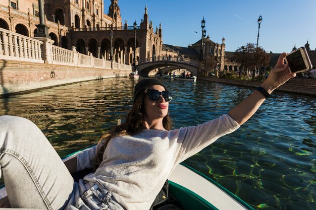 Linda mujer tomando selfie en barco