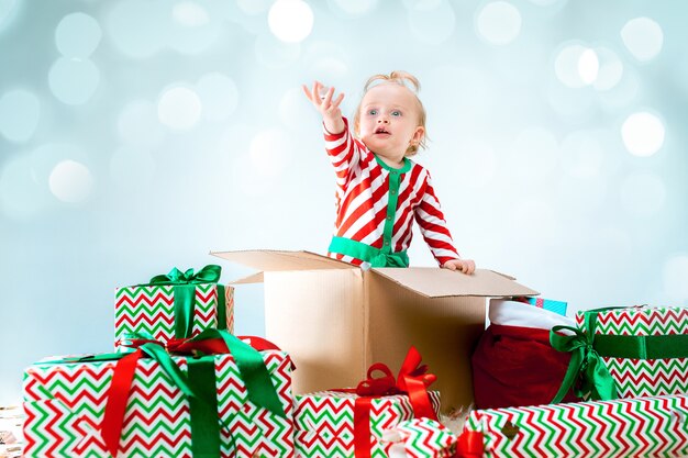 Linda niña de 1 año sentado en caja durante Navidad