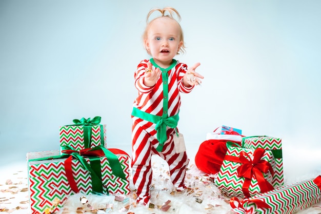 Linda niña de 1 año vistiendo gorro de papá noel posando en navidad