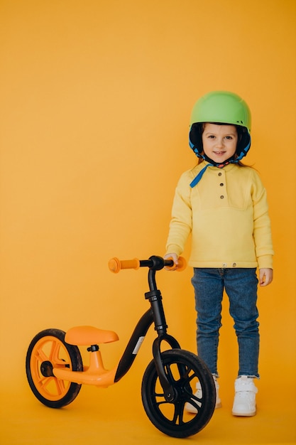 Foto gratuita linda niña aprendiendo a andar en bicicleta