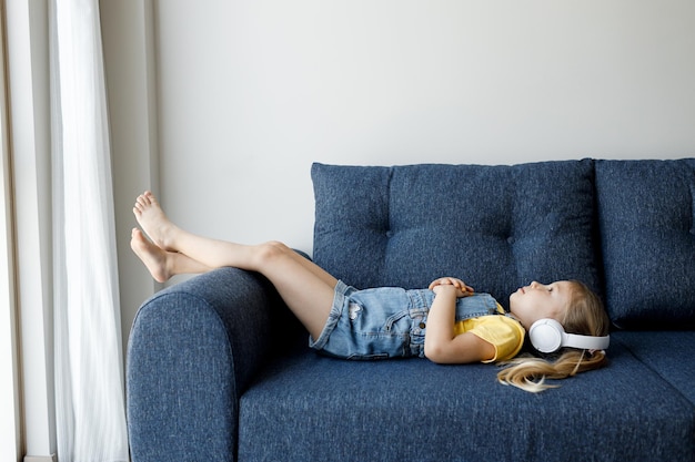 Foto gratuita linda niña en auriculares relajarse en casa