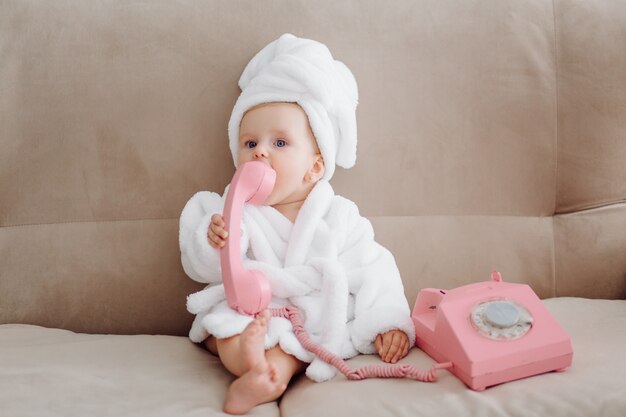 Linda niña en bata de baño blanca