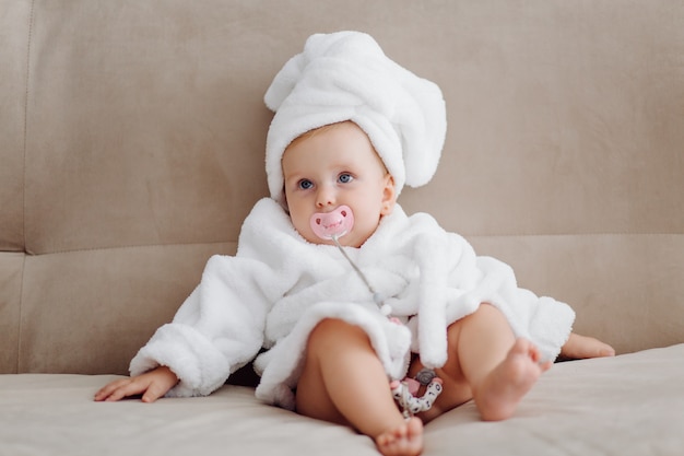 Linda niña en bata de baño blanca