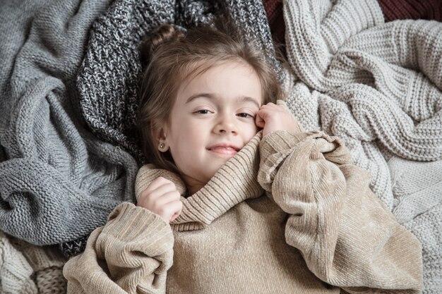 Linda niña divertida con un suéter de punto.