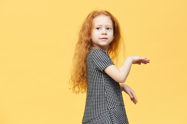 Foto gratuita linda niña europea encantadora en elegante vestido bailando con música, sintiéndose libre