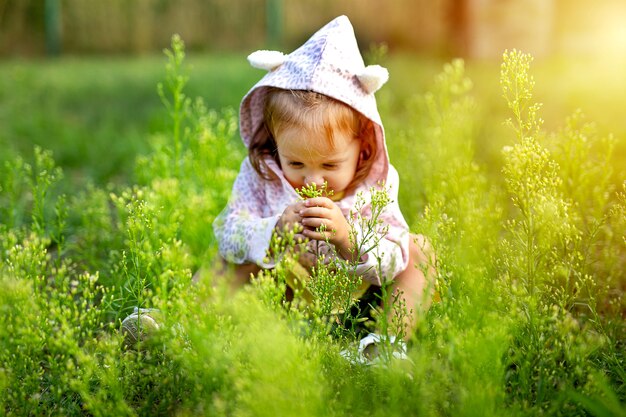 Linda niña jugando en el campo de hierba