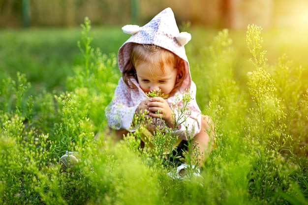 Linda niña jugando en el campo de hierba