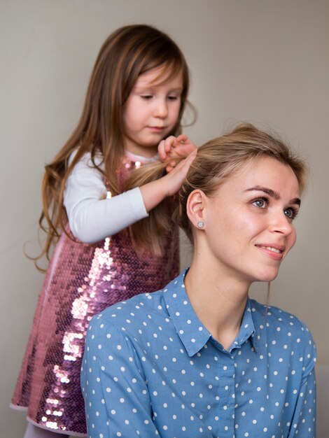 Linda niña jugando con el pelo de las madres