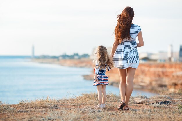 linda niña con madre cerca del mar