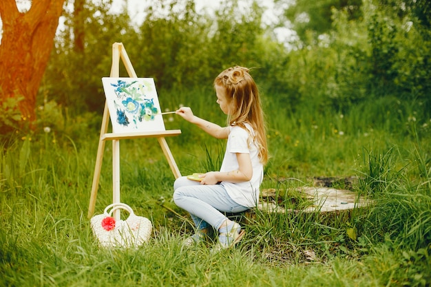 Linda niña pintando en un parque