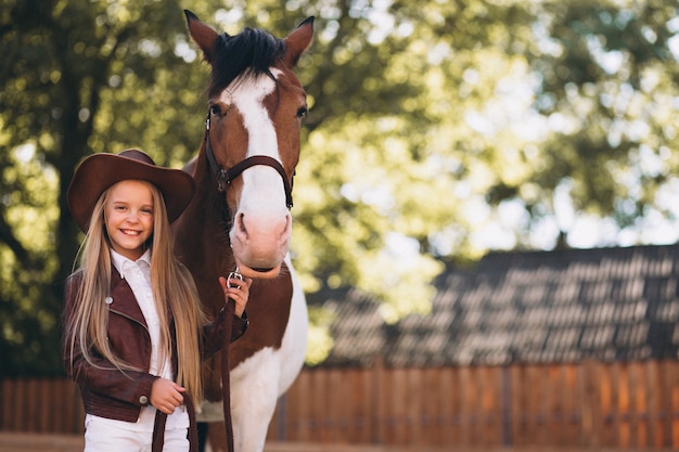 Foto gratuita linda niña rubia con caballo en el rancho