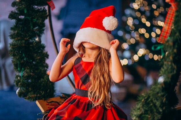 Linda niña en santa sombrero y vestido rojo