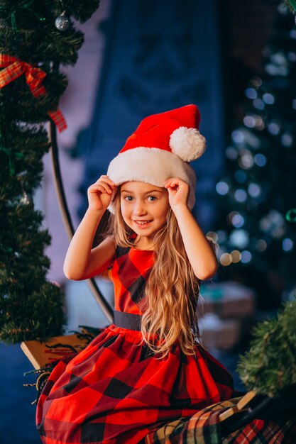 Linda niña en santa sombrero y vestido rojo